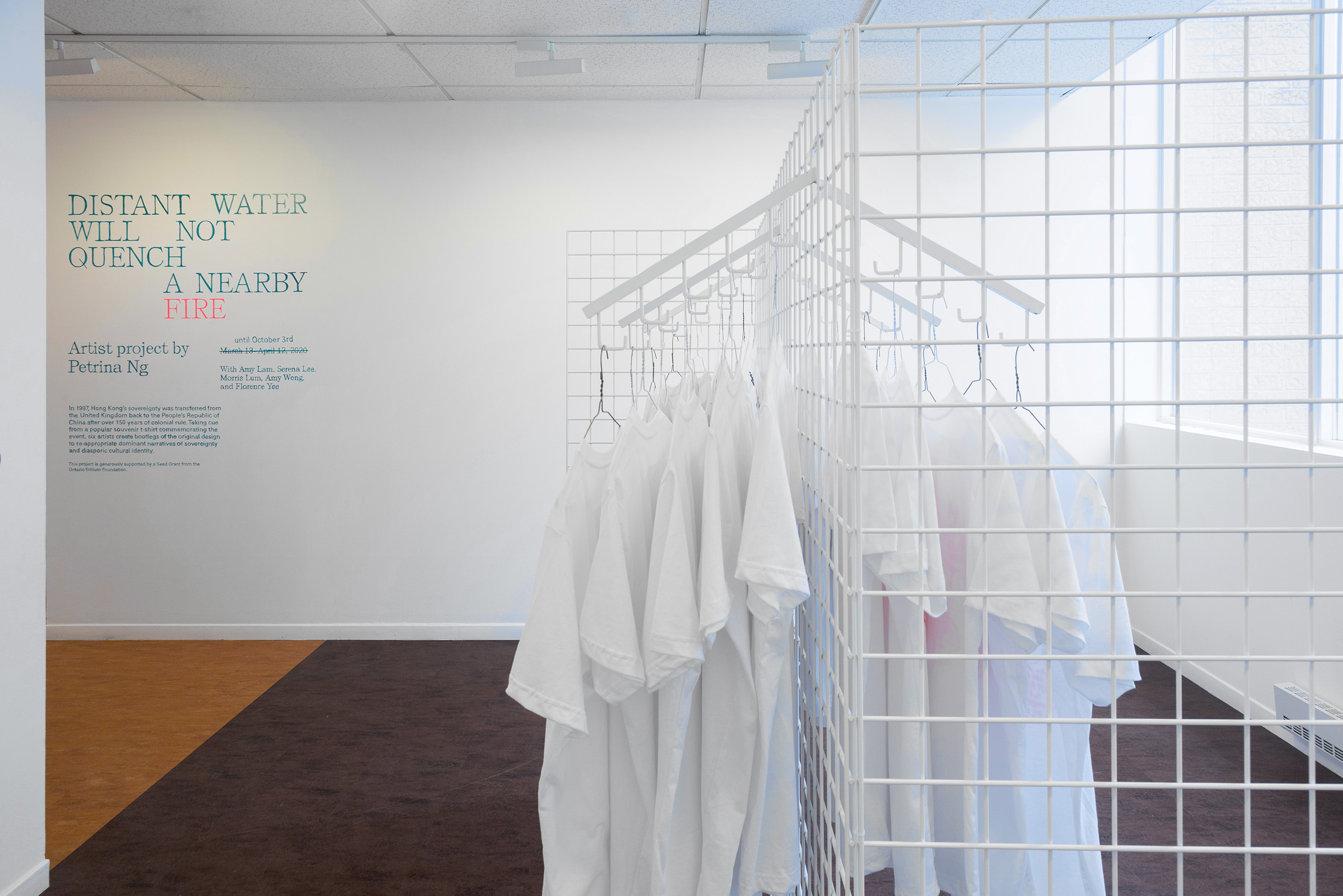 Side view of white t-shirts hanging on a white wire rack