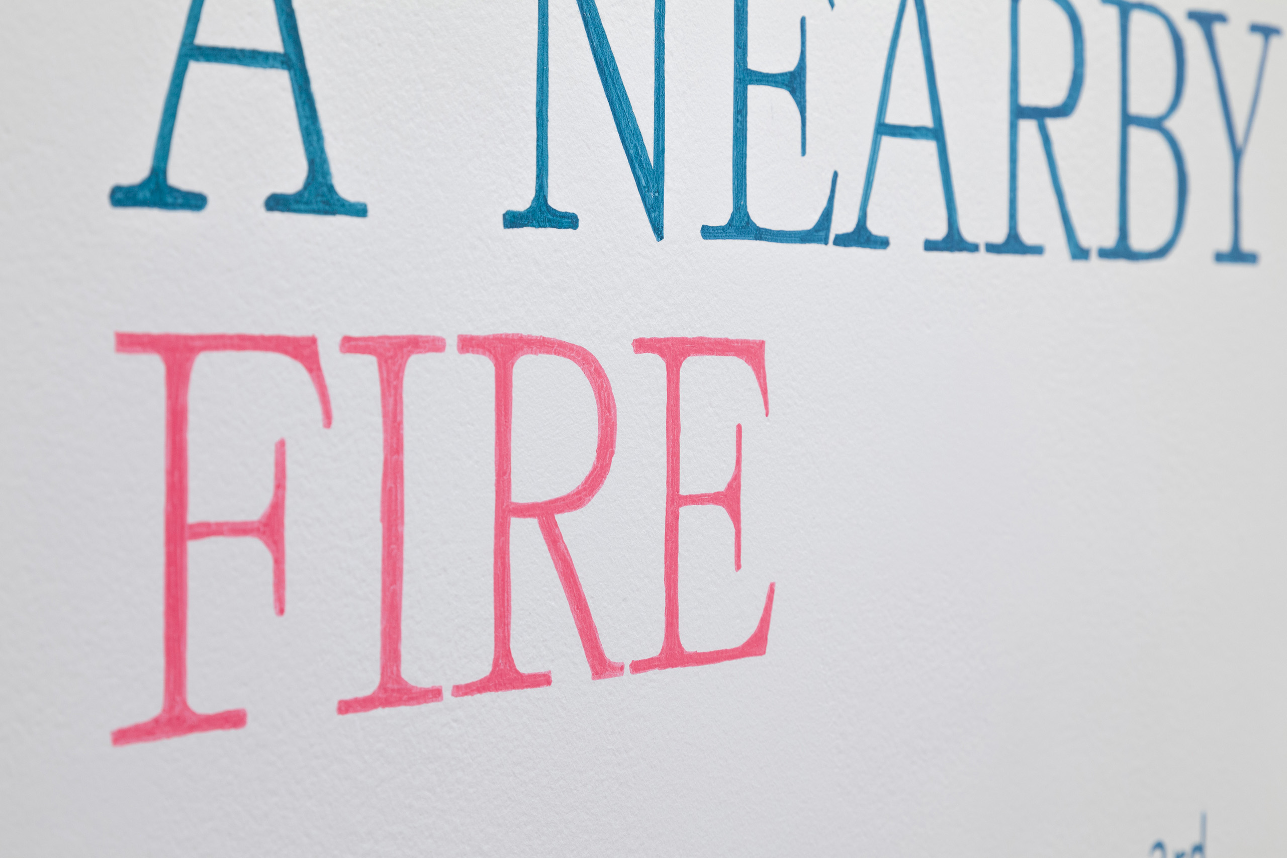 Close view of the words "A NEARBY FIRE" in teal and fushia