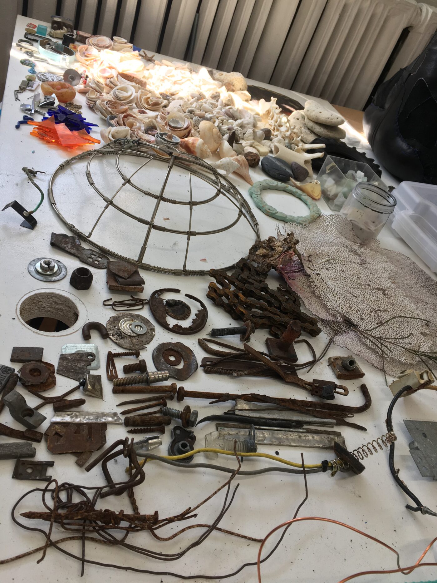 Image shows a white tabletop covered in pieces of scrap metal of various sizes.